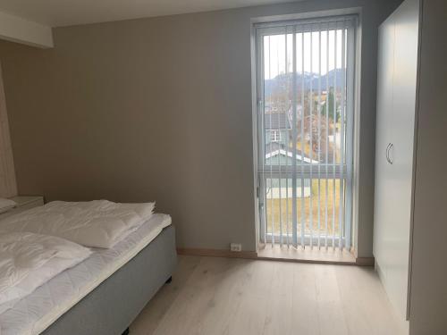 een slaapkamer met een bed en een groot raam bij Folkestadvegen 23Q in Bø