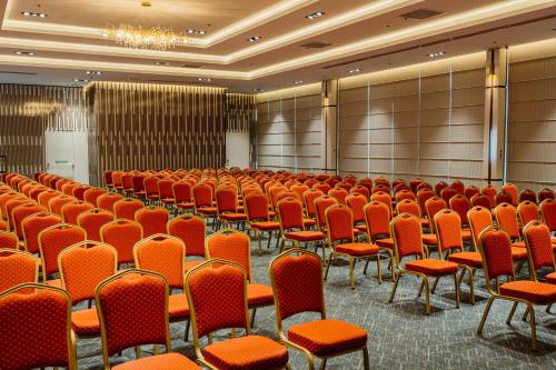 an empty conference room with orange chairs in it at Best Western Plus Batumi in Batumi