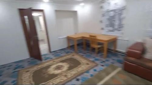 um pequeno quarto com uma mesa e um sofá em Sulaimankul em Kochkorka