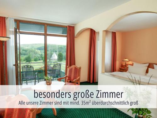 a hotel room with a bed and a balcony at Hotel Am Kurhaus mit erstem Ayurveda Center Sachsens - direkt am Gesundheitsbad ACTINON & Kurpark in Bad Schlema