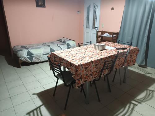 a table with chairs and a bed in a room at Departamento barrio Loma in Comodoro Rivadavia
