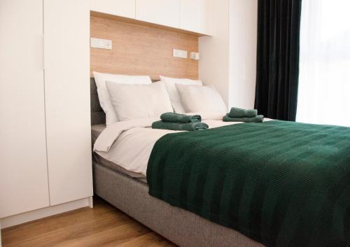 a large bed with two green towels on it at Apartament Wiśniewski - nad Jeziorem Drwęckim in Ostróda