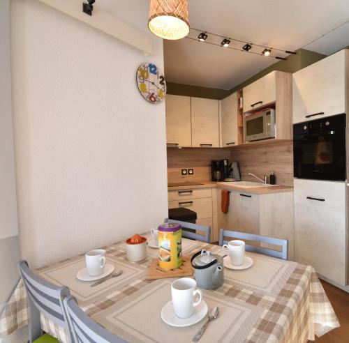 uma pequena cozinha com uma mesa e uma mesa e cadeiras em Point d'or L21 - Hossegor appartement 4 personnes plage piscine em Soorts-Hossegor