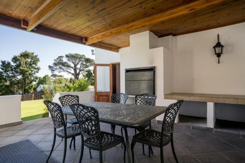a dining table and chairs on a patio at La Felicita Boutique Self Catering Villas in Somerset West