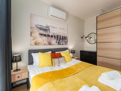 1 dormitorio con 1 cama de color amarillo y blanco en Apartament Przy Plaży z Garażem i Rowerami - by Perłowa Przystań Rent en Sianozety