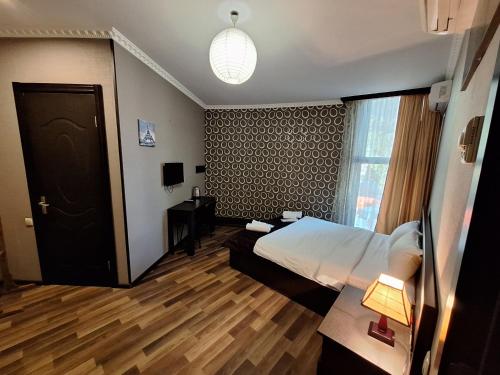 a hotel room with a bed and a window at Georgian Paradise in Kutaisi