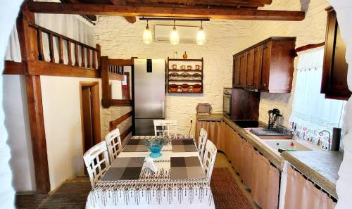 uma cozinha com uma mesa e cadeiras numa cozinha em Mannashouse em Émbonas