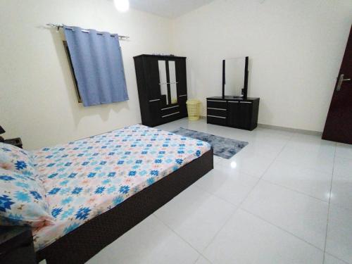 a bedroom with a bed and a dresser in it at New! Relaxing Family Home just 8 mins to waterfront in Sharjah