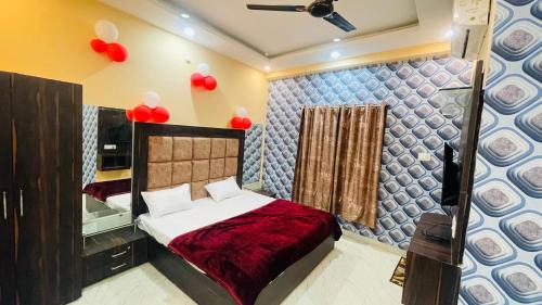 a bedroom with a bed with red balloons on the wall at Star hotel in Jabalpur