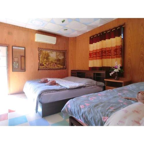 Zimmer mit 2 Betten in einem Zimmer in der Unterkunft Pernjai Homestay บ้านคำข้อน in Ban Lao