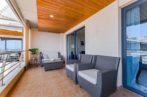 a balcony with chairs and tables on a building at Ático en Balcón de Los Gigantes in Puerto de Santiago