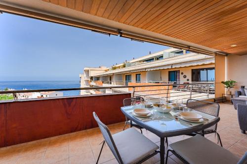 a balcony with a table and chairs and the ocean at Ático en Balcón de Los Gigantes in Puerto de Santiago