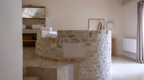a room with a stone wall and a table at La Sommità Relais & Chateaux in Ostuni