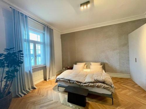 Exklusive Wohnung im Herzen von Göppingen في غوبينغِن: غرفة نوم بسرير ونافذة كبيرة