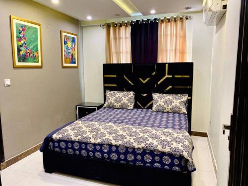 1 dormitorio con 1 cama grande y edredón morado en 401-NEXT INN Quality Living Starts Here! en Lahore
