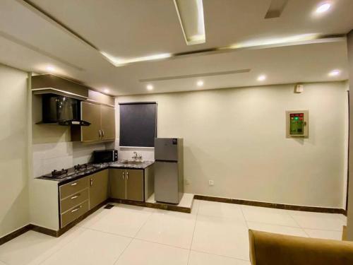 a kitchen with a refrigerator and a counter top at 401-NEXT INN Quality Living Starts Here! in Lahore
