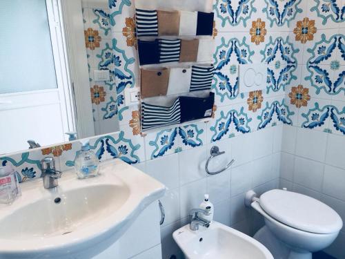 a blue and white bathroom with a toilet and a sink at Colori Salentini Appartamento CORALLO in Sant'Isidoro