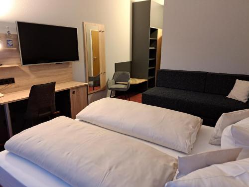 a hotel room with two beds and a desk with a television at Best Western Comfort Business Hotel Düsseldorf-Neuss in Neuss