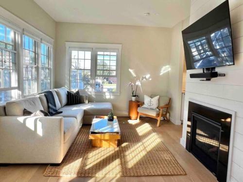 a living room with a couch and a fireplace at Luxury Water-View West End Condo in Provincetown