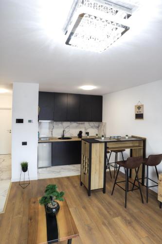 a kitchen with a table and some chairs in a room at Tesla Sky Apartment in Ledine