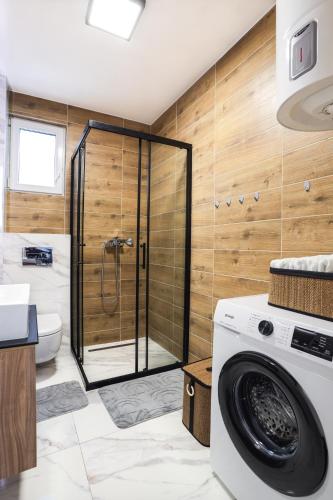 a washing machine in a bathroom with a shower at Tesla Sky Apartment in Ledine