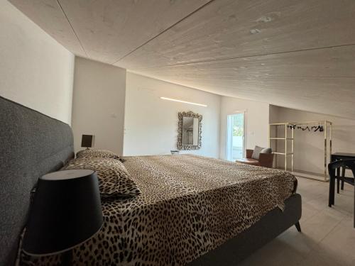 Dormitorio con cama de leopardo y espejo en Villapinetacervia en Cervia