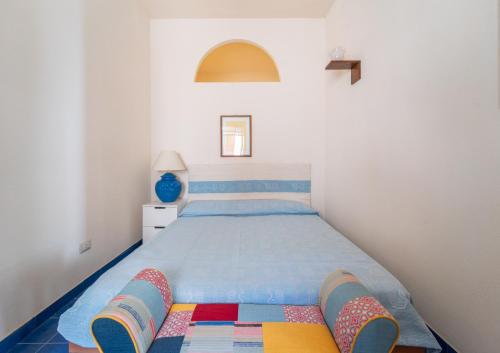 a bedroom with a large bed with colorful pillows at Burantì Guest House in Alghero