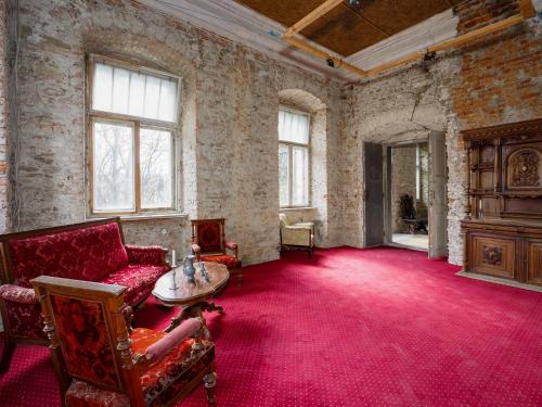 an old room with a couch and a table at Zamek Międzylesie in Międzylesie