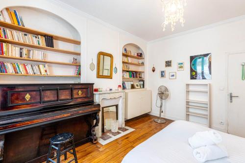 - un salon avec un piano et une cheminée dans l'établissement GuestReady - A happy place to stay in Paris, à Paris