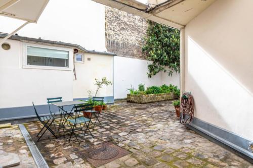 un patio avec des chaises et une table dans un bâtiment dans l'établissement GuestReady - A happy place to stay in Paris, à Paris