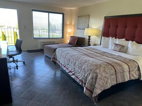 een hotelkamer met een groot bed en een bureau bij Geneva Wells Inn in Lake Geneva