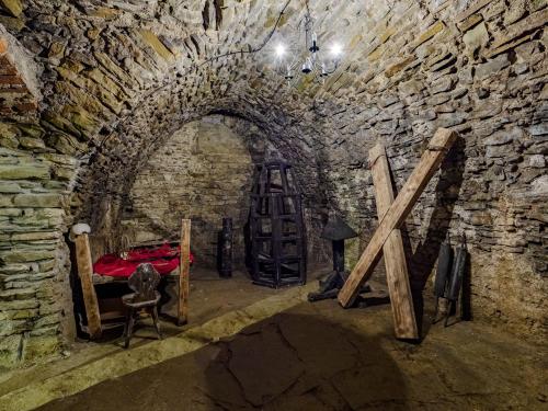 a stone tunnel with a ladder and a table in a room at Zamek Międzylesie in Międzylesie