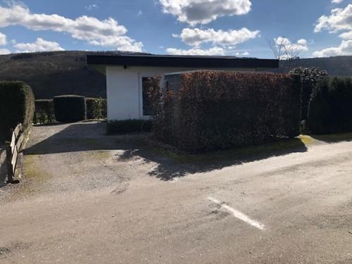 a building with a hedge next to a road at Chalet N°5 in Treignes