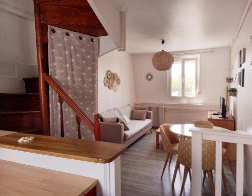 ein Wohnzimmer mit einem Sofa und einem Tisch in der Unterkunft Chez Sophie in Trouville-sur-Mer