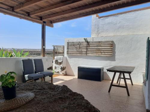 a patio with two chairs and a wooden table at Sunset Terrace in La Oliva