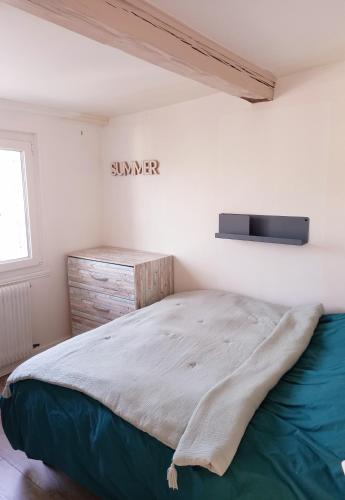 une chambre avec un lit et un panneau sur le mur dans l'établissement Chez Sophie, à Trouville-sur-Mer
