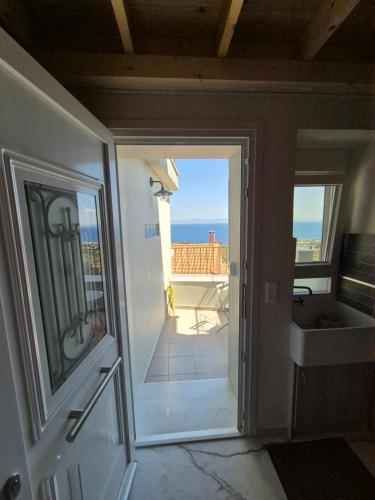 een deur naar een kamer met uitzicht op een balkon bij Ελιά Ξενώνας / Elia Xenonas in Mytilini