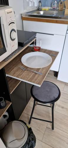 a counter with a sink and a stool in a kitchen at Némo Petit studio cosy. in Orville