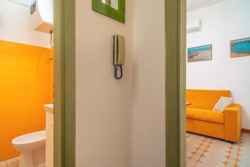 een badkamer met een gele bank en een telefoon aan de muur bij Pied a Terre Taormina mare in Taormina