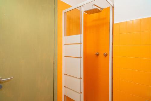 een douche in een badkamer met een oranje muur bij Pied a Terre Taormina mare in Taormina