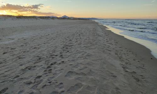 a beach with footprints in the sand and the ocean at Casa Mayago, terraza y solárium in Pego