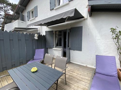 a wooden table and chairs on a patio at La Villa du Grand Large in Biscarrosse