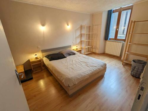 sypialnia z łóżkiem i drewnianą podłogą w obiekcie Maison individuelle au cœur de Millau w mieście Millau