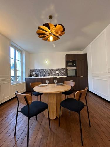 een keuken met een tafel en stoelen in een kamer bij Reims Cathédrale Hyper Centre in Reims
