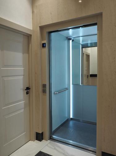 a glass shower door in a room with a mirror at Catedral - Apartamentos Burgos Deluxe in Burgos