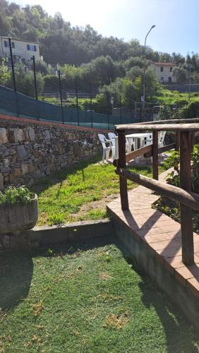 a wooden bench sitting next to a stone wall at AAUT IL NOCE LEIVI codice CITRA 010029-LT-0025 in Leivi