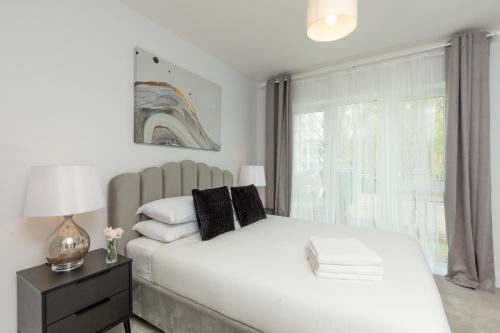 a bedroom with a large white bed and a window at Deluxe South Central Apartment in London
