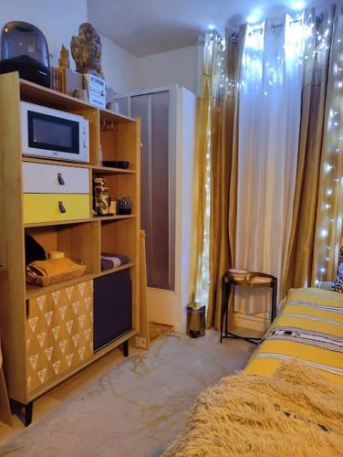 - une chambre avec un lit et une commode avec un four micro-ondes dans l'établissement SINGLE STUDIO QuartierLatin, à Paris