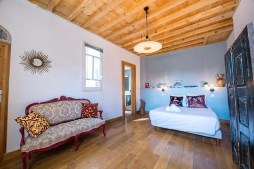 une chambre avec un lit et un canapé dans une pièce dans l'établissement Le Bacchus, Grand T2, Centre Historique, à Montpellier