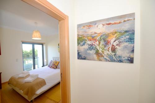 um quarto com uma cama e um quadro na parede em Vela - Apartment in complex near the beach em São Martinho do Porto